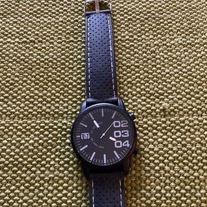 Ladies black watch, strap has white stitching made of like a rubber material.